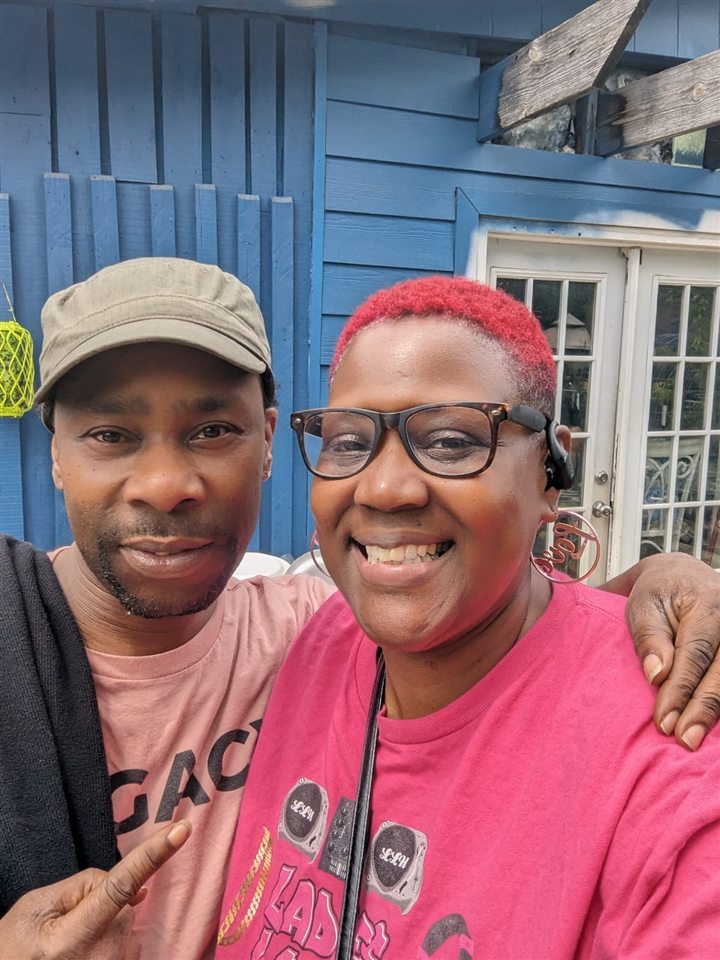 Two friends take a selfie in front of the blue house, 2024.